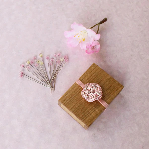 Pink and yellow glass head sewing pins in a little box made with cherry wood.